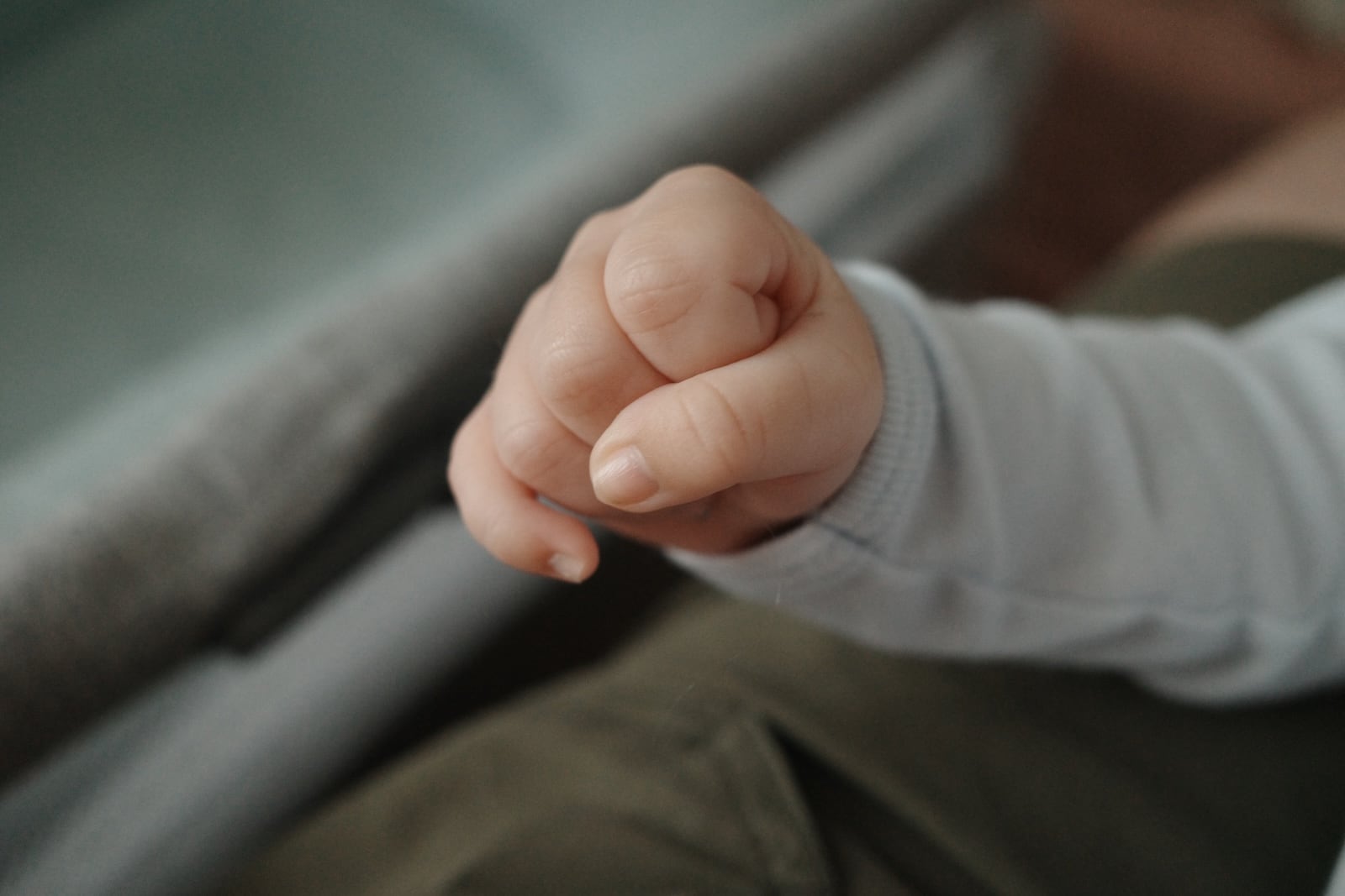 A baby's hand curled into a tiny fist