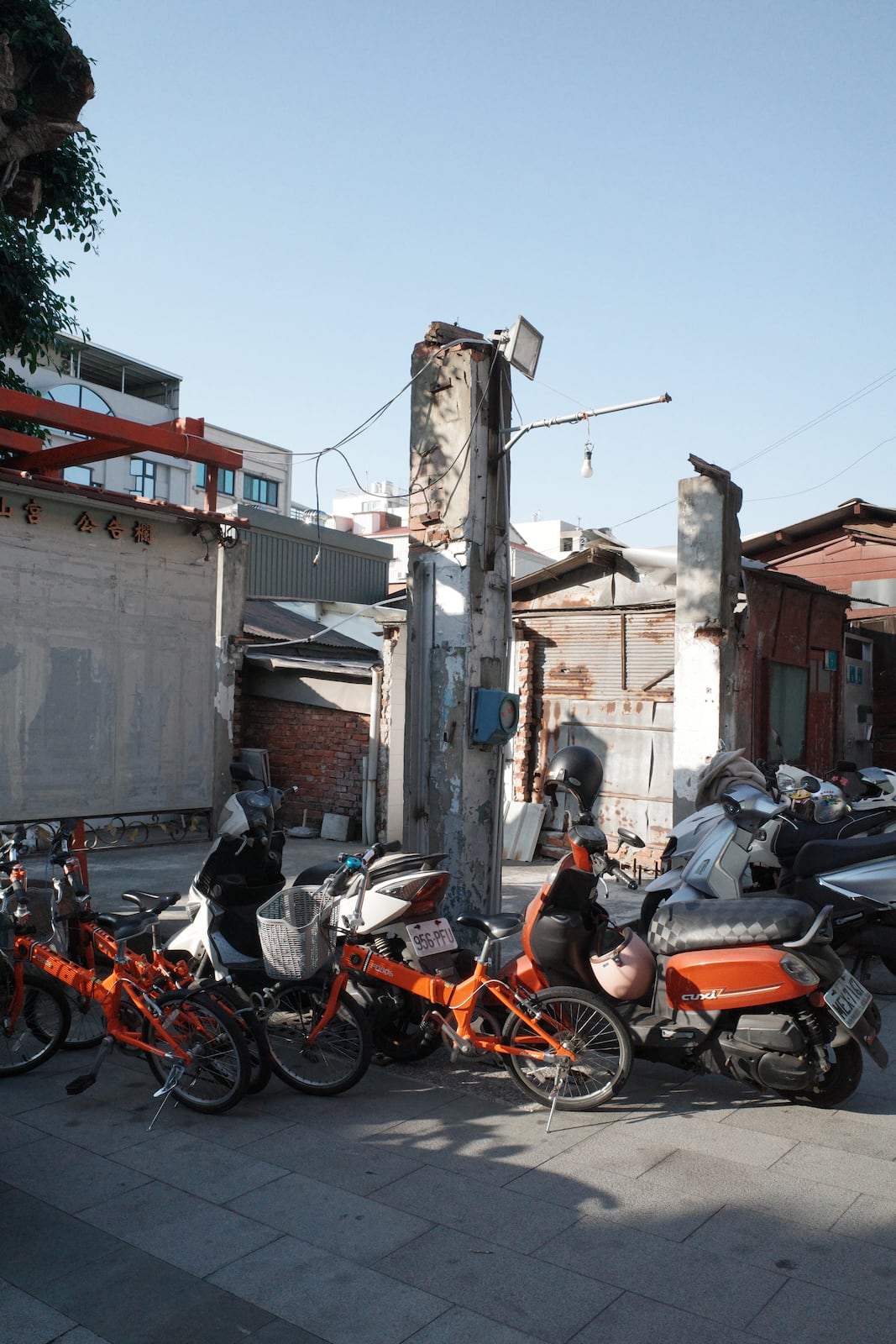 Some red bicycles and scooters next to the ruins of a building