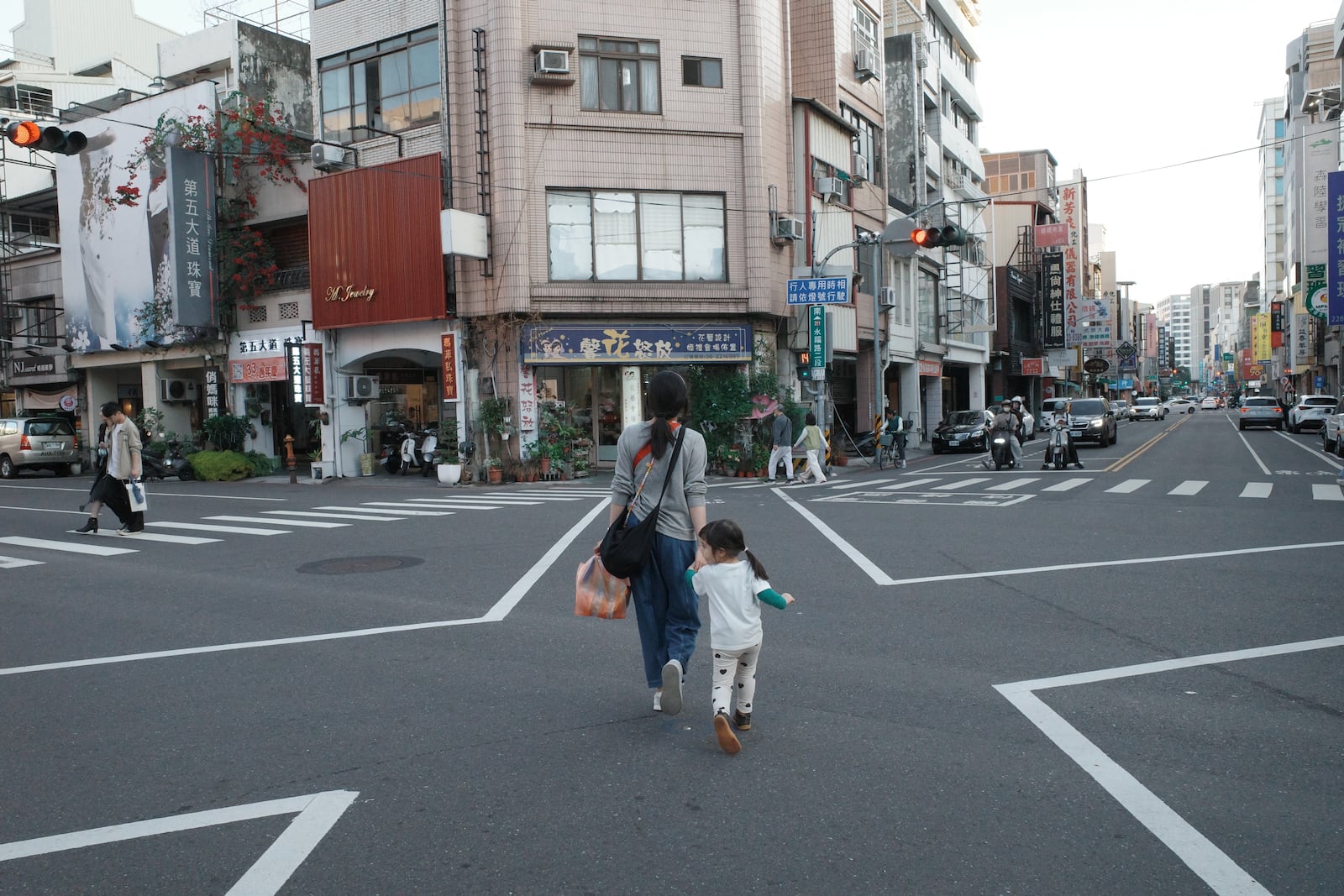 A young woman and her daughter crossing a street in Tainan